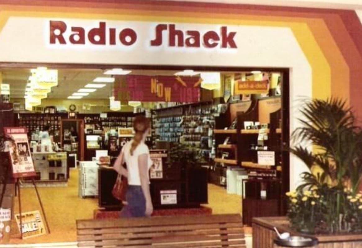 A woman gazes into a Radio Shack at her local mall. 
